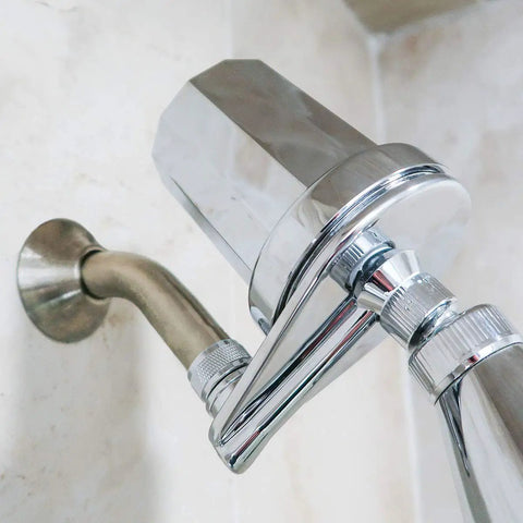 Chrome inline shower filter with easy replace cartridge cuts chlorine by up to 98 percent for smoother skin and hair, mounted on shower arm.