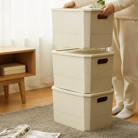 Person stacking beige storage bins with handles in a room; alternative to Six Pack Plastic Storage Bins With Lids For Closet Shelves And Desktop
