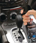 Hand using Two Pack 10 Oz Compressed Gas Dusters for quick cleaning of car interior near gear shift, blows away dust lint and debris.