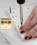 Spring Loaded Cabinet Door Hinges With Half Overlay For RV And Camper Cabinets being installed on white panel with screwdriver.