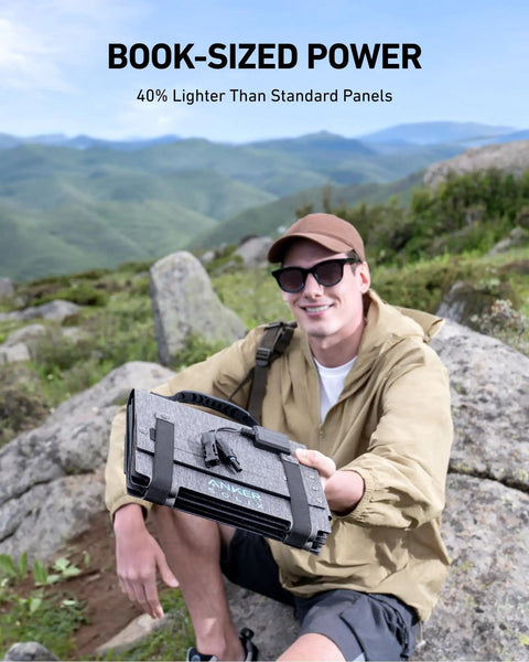 Person holding SOLIX C300 DC Power Bank Station with 60W solar panel in a mountain setting, highlighting portability.