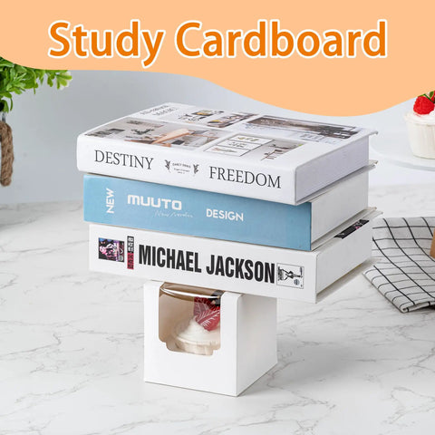 Books stacked on 50 Pack Cupcake Containers With Windows, Food Grade Cupcake Boxes With Lids, in a kitchen setting.