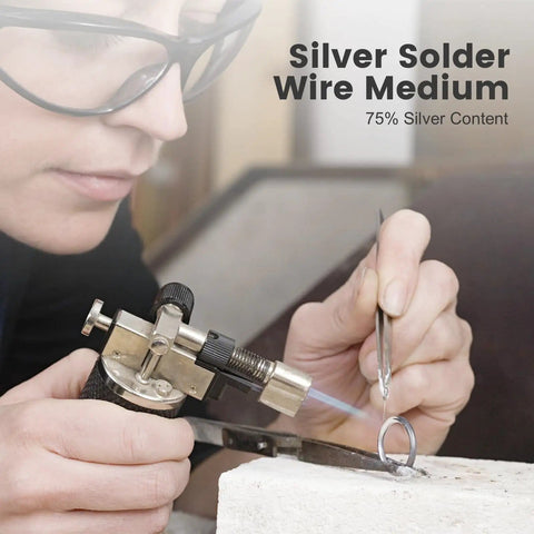 Person using hard silver solder wire with torch on jewelry ring, 75% silver content