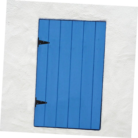 Blue wooden gate with black metal hinges installed on white stucco wall