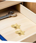 Retro Golden Metal Duckbilled Hasp Lock Toggle Latch Set on wooden drawer with a wrench and rope, ideal for DIY repairs.