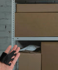 Hand holding Beefy Heavy Duty Stainless Steel Square Pipe Shelf Bracket with boxes in background