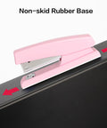 Pink Office Desktop Stapler With 25 Sheet Capacity And Holds Up To 120 Staples, shown with non-skid rubber base on a desk edge.
