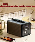 Heavy Duty Portable Power Station 220V Solar Generator With Multi Outlets Compact Backup Energy Kit Trail Ready For Campouts Road Trips And Weekend Getaways Black on a table with a phone charging.