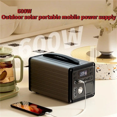Heavy Duty Portable Power Station 220V Solar Generator With Multi Outlets Compact Backup Energy Kit Trail Ready For Campouts Road Trips And Weekend Getaways Black on a table with a phone charging.