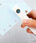 One-Handed 2mm Circle Pattern Embosser With Built-In Waste Storage, Easy-Squeeze Punch Tool in use on blue paper, Sky Blue.