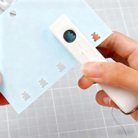 One-Handed 2mm Circle Pattern Embosser With Built-In Waste Storage, Easy-Squeeze Punch Tool in use on blue paper, Sky Blue.