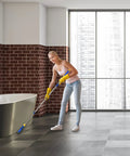 Woman using Long Reach Grout Brush With Extendable Stainless Steel Handle For Floor To Wall Cleaning No Knees Back Saving Tile Scrub