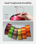 Hand holding spool of Silk PLA Filament 1.75mm Magenta Silk Pink 1kg, shown with 360-degree bend for durability demonstration.