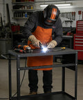 Welder using a 36 By 18 Inch Welding Table With 0.63 Inch Fixture Holes, Non Slip Foot Pads, Built To Last Carbon Steel Frame