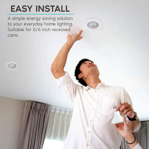 Man installing Four Pack LED PAR30 Flood Light Bulbs 75W Equivalent 5000K Bright White in recessed ceiling fixture indoors.