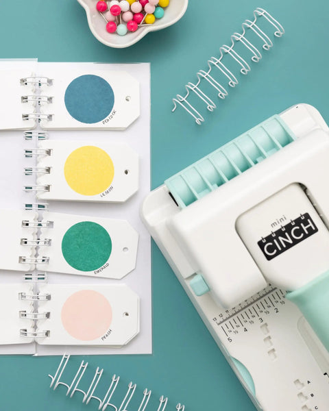 Mini Cinch Binding Tool For DIY Books And Notebooks With Wire Or Spiral Coils Pro Grade Mini Binding Machine near colored paper samples.