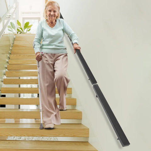 Built Damn Tough Wall Mount Stair Handrail In Sleek Black Finish Crafted From Genuine Stainless Steel With Sure Grip Non Slip Rail And Hassle Free Setup Supports Up To Two Hundred Pounds used by a senior on stairs.