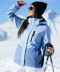 Woman skiing wearing Women's Waterproof Ski Jacket With Fleece Lining, Built For Cold Weather, Triple Layer Insulation Snow Coat, Windproof Hooded Rain Jacket, Blue Large, Snow Day Ready Winter Gear.