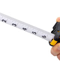 Person holding Beefed Up Heavy Duty 25 Foot Contractor TS Wide Blade Tape Measure With Backside Print And Manual Lock, blade extended