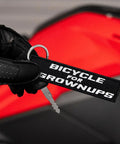 Dope Bicycle For Grownups Keychain For Riders, Pocket Sized Metal Key Ring For Motorcycles Scooters Cars And Gifts held by gloved hand