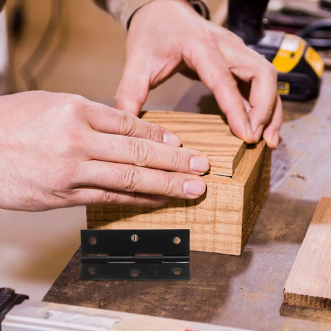 Person fitting a wooden box with a Ten Pack Black Stainless Steel Small Box Hinges With Screws For Cabinet Doors And Wooden Boxes