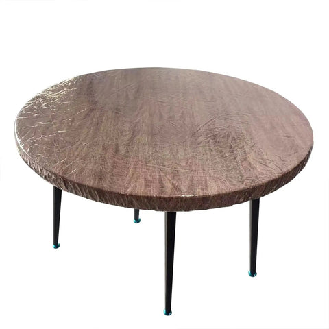 Crystal Clear Round Vinyl Tablecloth For 22 To 26 Inch Tables Heavy Duty Elasticized Fit With Elastic Edges Waterproof Non Yellowing Protection Transparent Plastic Cover That Shields Surfaces From Spills And Scratches, shown on table surface.