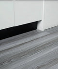 Real Wood Look Vinyl Floor Roll Featuring Dead Simple Peel And Stick Setup Super Wide Layout For Quick Room Makeovers Non Slip Grip and sleek grey wood grain surface in a kitchen setting.