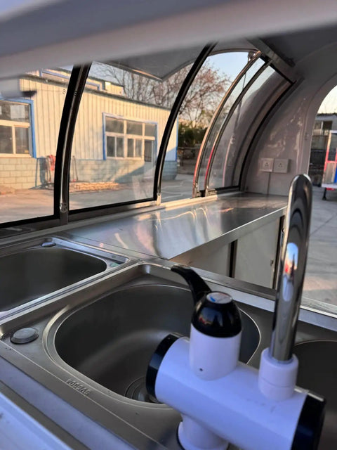 Interior view of a Ready To Roll Custom Mobile Food Truck Trailer with stainless steel prep sink and faucet.