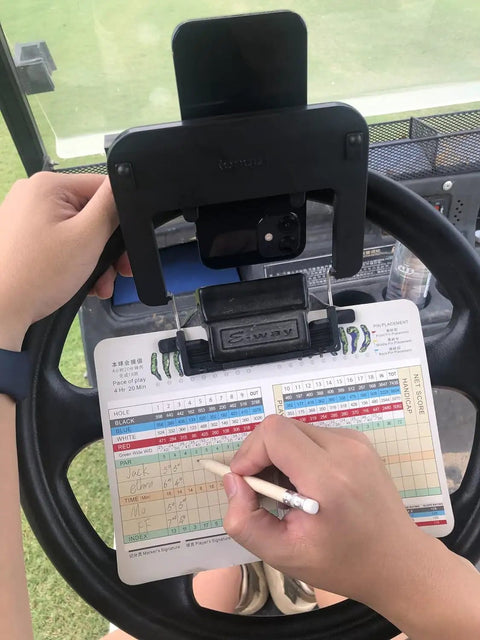 Rock Solid Golf Cart Phone Holder Steering Wheel Mount Spring Loaded Grip holds phone snug while player writes on scorecard.