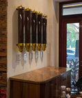 Super Heavy Duty Wall Mounted Coffee Bean Dispenser 10 Liter Airtight Gold Canisters With Clear Acrylic Front And Slam Shut Aluminum Lid For Busy Cafe Crew And Home Bars Set Of Four mounted on a wall with coffee beans inside.