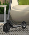 Image of an electric scooter with Honeycomb Scooter Wheel Replacement Tire With Shock Absorption Solid Tire For Adult Electric Scooters Stable Ride And Safe Performance Durable Design Easy Install Replacement Part For Wide Range Of Models on a wooden deck.
