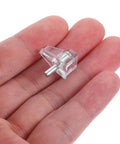 Hand holding a clear shelf peg from 100 Pcs Plastic Cabinet Shelf Support Pegs For Bookshelves And Cabinets, Clear DIY Bracket Pegs To Stop Wobble And Keep Shelves Sturdy, Easy Install For Home And Balcony Furniture Projects.