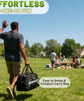 Man carrying compact bag for Epic Backyard Golf Chipping Game, heading to picnic in park, sunny day ambiance.