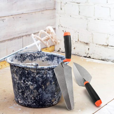 4 Pack Pro Grade Masonry Hand Tools Set with 6 Inch Pointing Trowels and 9 Inch Gauging Trowels next to plaster bucket