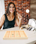 Wooden Jewelry Storage Tray With Four Compartments Multi Grid Ring Holder And Accessory Organizer Plate For Dresser Vanity And Makeup Station To Keep Your Bling Tidy on a makeup table.