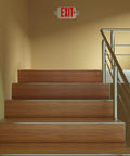 Red exit sign with emergency lights above stairs, Two Pack Exit Sign With Emergency Lights And Battery Backup, indoor hallway view.