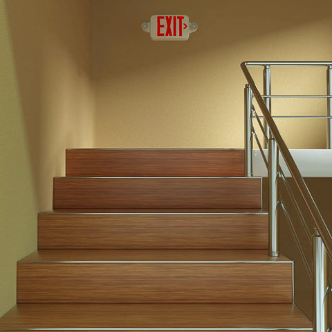 Red exit sign with emergency lights above stairs, Two Pack Exit Sign With Emergency Lights And Battery Backup, indoor hallway view.