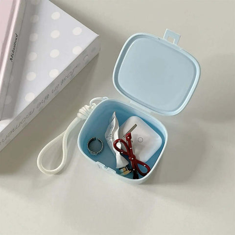 Badass Hella Tough Shockproof EDC Case For Bluetooth Headphones with red scissors, ring, and batteries inside.