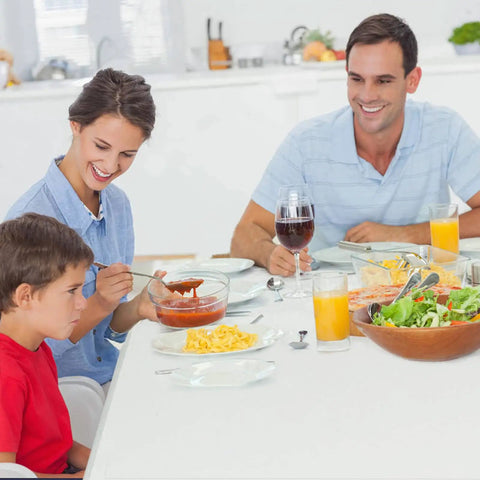 Family dining on a Heavy Duty 4 Foot Folding Table For Indoor Outdoor Use With Handle Portable Square Plastic Dining Table Locking Legs 330 Lb Load Capacity Ideal For Picnics Parties Camping Tailgating indoors.