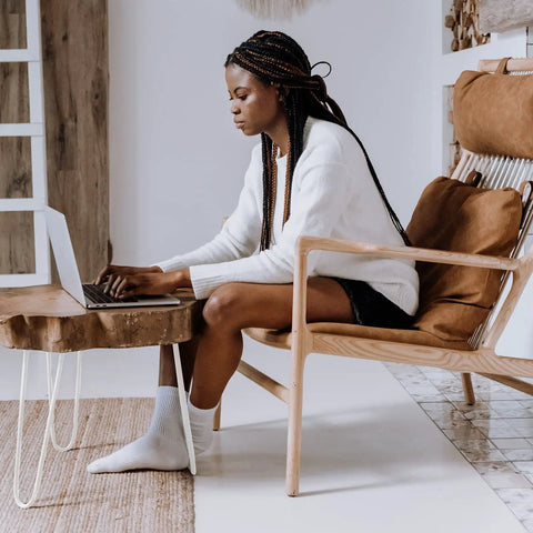 White room with a wooden chair and a person using a laptop on a table with 16 Inch Hairpin Leg Set Of 4 For Furniture And DIY Projects.
