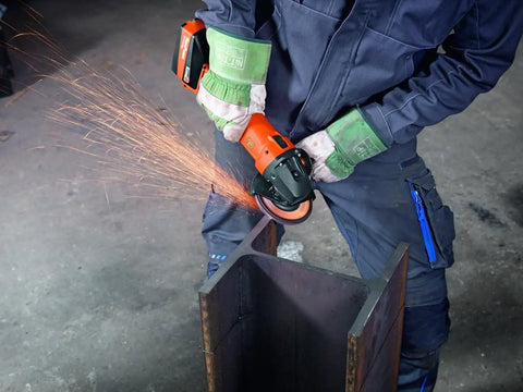 Person using a Compact 18V Brushless Cordless Angle Grinder With 125 MM Disc and Rock Solid Dust Resistant Design for cutting metal.