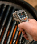 No Touch Infrared Thermometer For Cooking And BBQ Laser Temperature Gun With Digital Display held over a hot grill