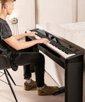 Man playing digital piano with sustain pedal for keyboards and digital pianos with polarity switch one quarter inch input