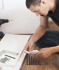 Man assembling furniture with 141 Piece Furniture Bolts And Nuts Kit For Beds And Cribs, Aluminum Alloy Screws Set For Wood Repair.