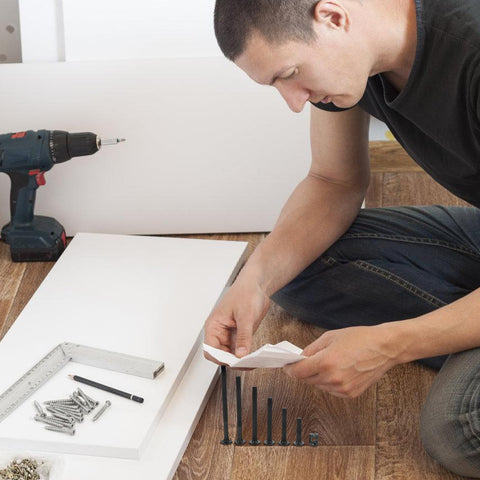 Man assembling furniture with 141 Piece Furniture Bolts And Nuts Kit For Beds And Cribs, Aluminum Alloy Screws Set For Wood Repair.