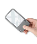 Hand holding Multi Power LED Lighted Pocket Magnifier With 2.5X Main Lens, 4.5X And 6X Lenses, Ultra Lightweight 1.4 Oz
