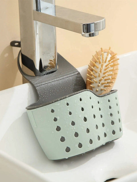 Double Deck Faucet Mount Kitchen Sink Organizer With Adjustable TPR Rubber Sponge Soap And Scrubber Storage Basket above a sink, in mint green.