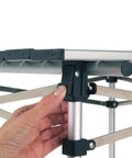 Close-up of hand assembling the Outdoor Folding Table with Aluminum Slat Top and Snap Together Design Seats Four Carry Bag Included.