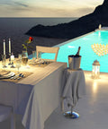 Elegant poolside dinner setup with 48 Piece LED Floating Candles Flameless Waterproof Tealights For Weddings And Pool Parties Centerpieces Yellow Warm White Light Create Romantic Vibe And Dinner Ambiance Battery Powered Tealights For Bathtub in water.