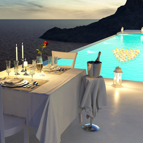 Elegant poolside dinner setup with 48 Piece LED Floating Candles Flameless Waterproof Tealights For Weddings And Pool Parties Centerpieces Yellow Warm White Light Create Romantic Vibe And Dinner Ambiance Battery Powered Tealights For Bathtub in water.